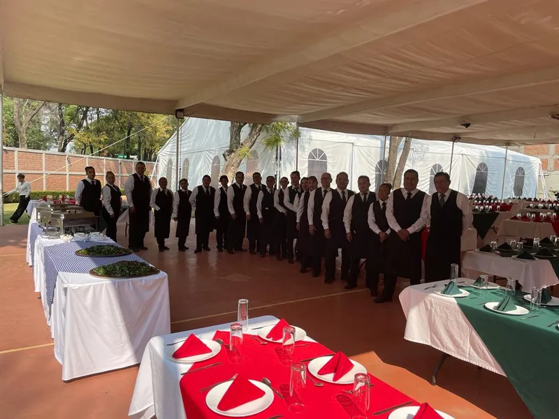 Equipo de meseros de AEventos formado junto a las estaciones de servicio