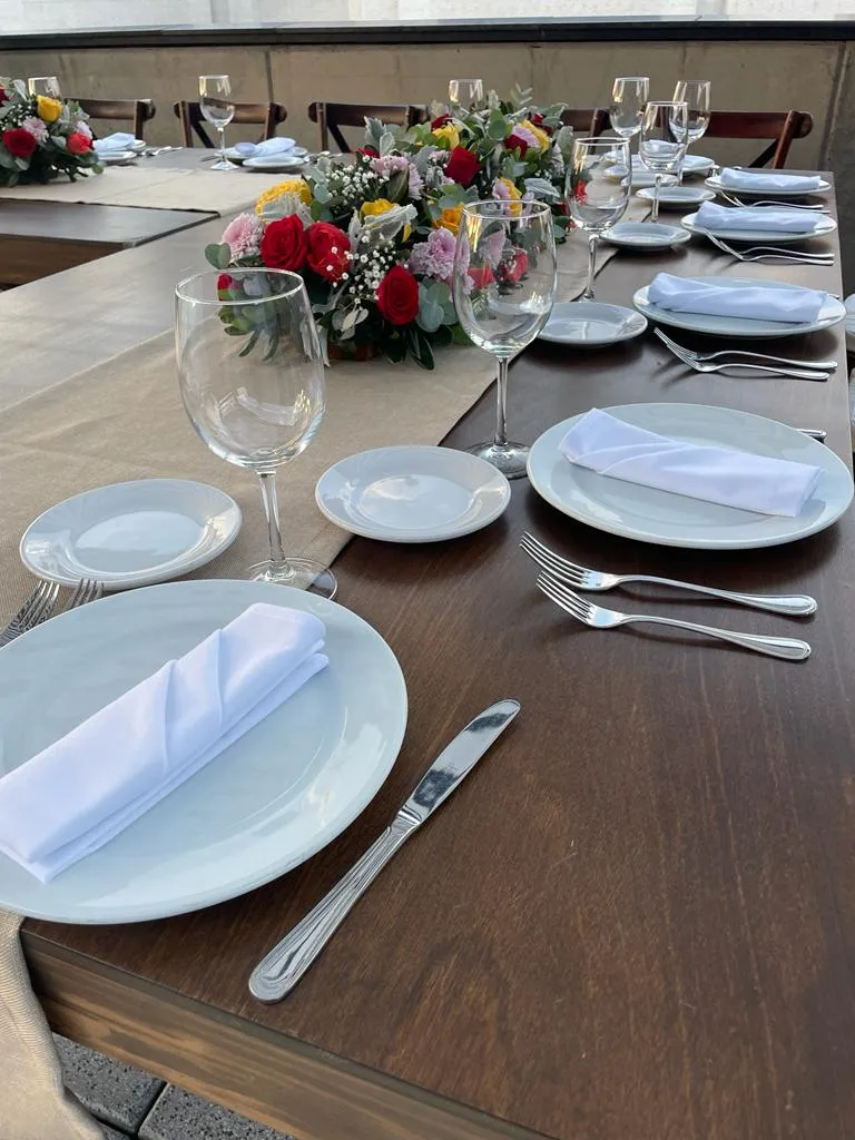 Mesa con loza, cristalería y flores para una cena servida