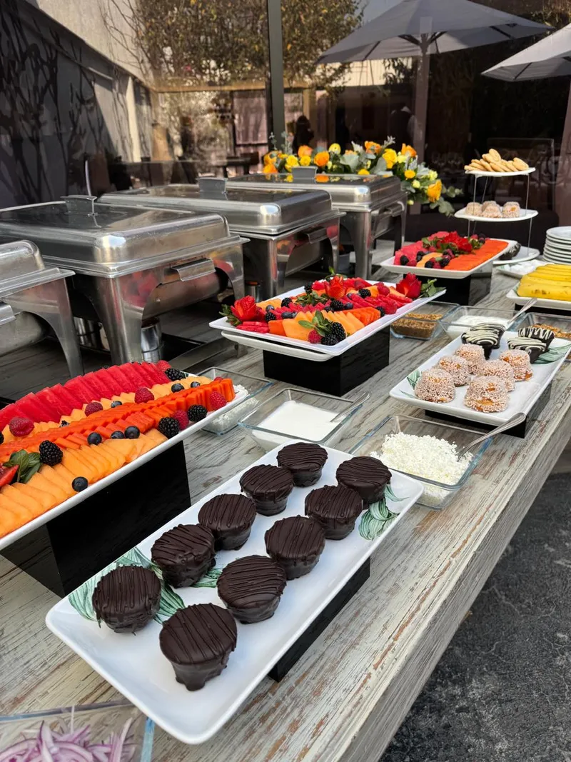 Estación de coffee break y brunch con fruta, postres y platillos calientes